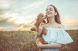 Beautiful girl is resting with a dog in a  field.